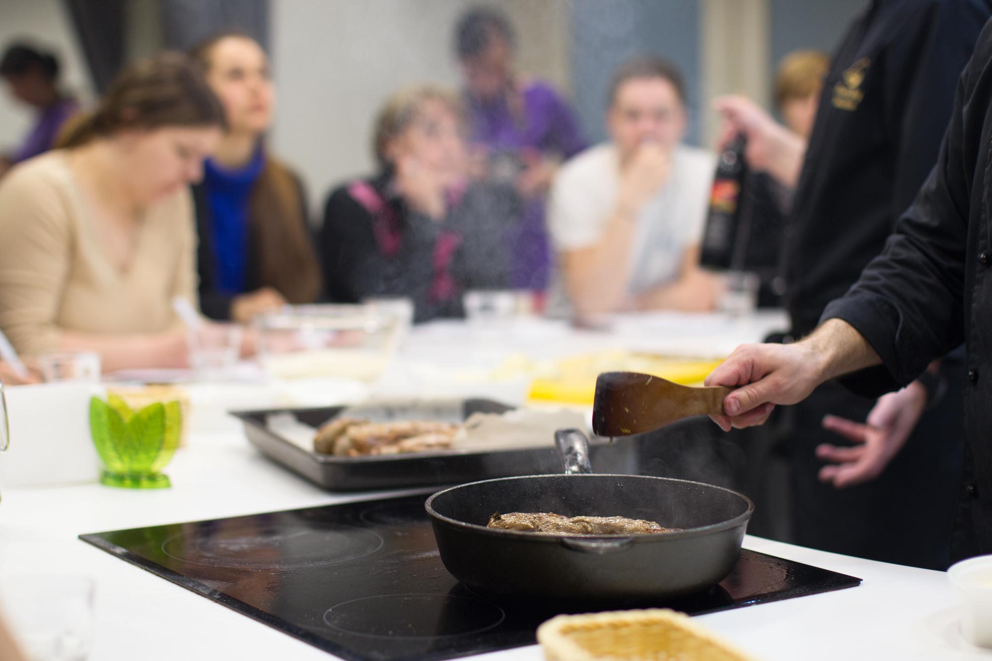 Instructor inviting participants around a stove